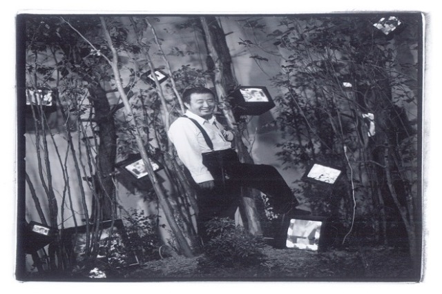 3. 울산시립미술관의 소장품인 케이지의 숲, 숲의 계시 앞에서 포즈를 취한 백남준.jpg